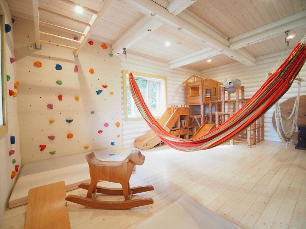 um quarto com uma parede de escalada e uma rede de descanso em Minanonno Play Village em Yoichi