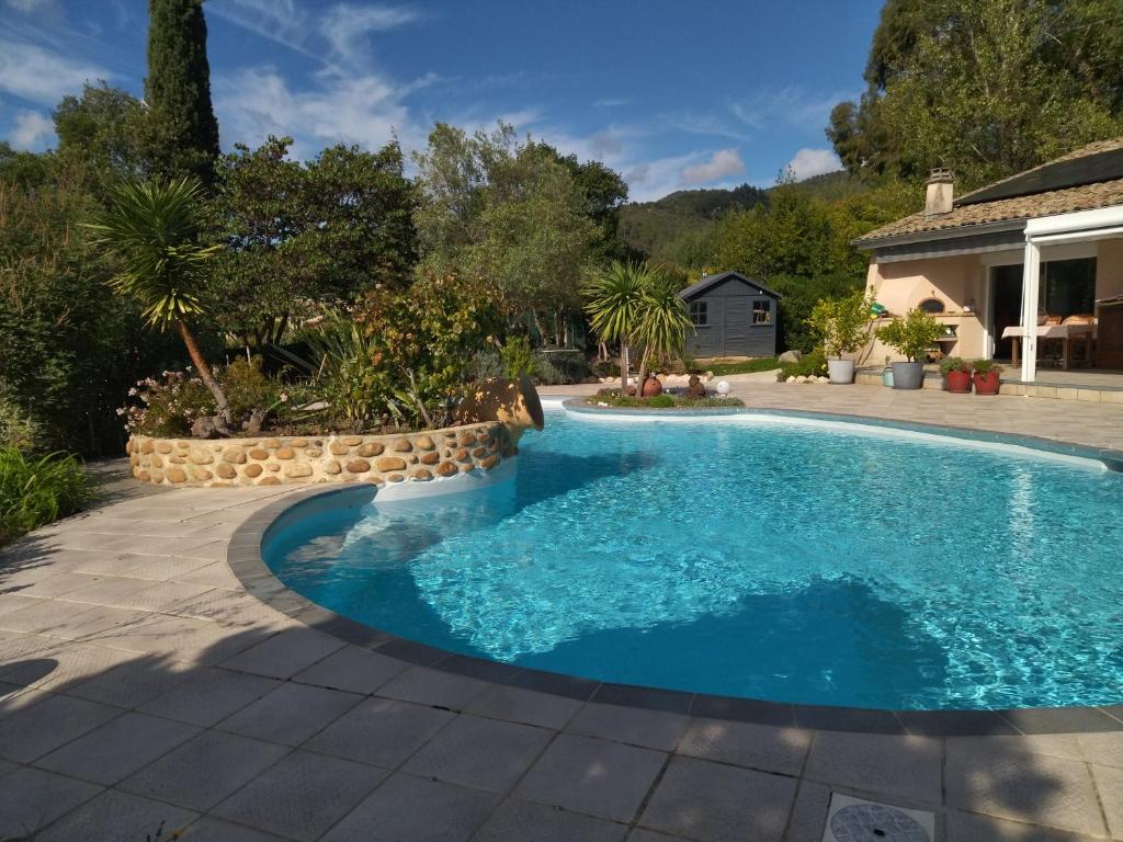 una piscina en un patio con patio en les petites roches en Saint-Fortunat-sur-Eyrieux