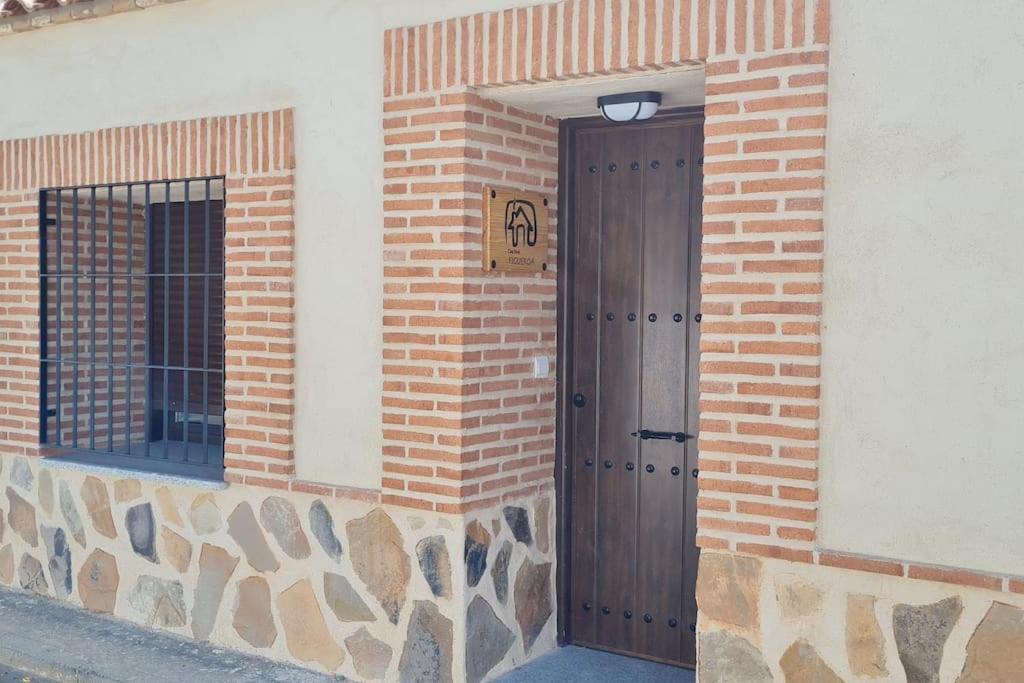 a door on a brick building with a sign on it at Casa FIGUEROA en Guadamur, próximo a Puy du Fou in Guadamur