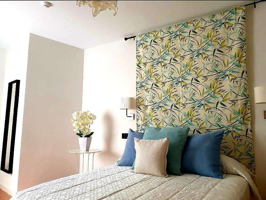 um quarto com uma cama com uma parede floral em LHome em Sevilha