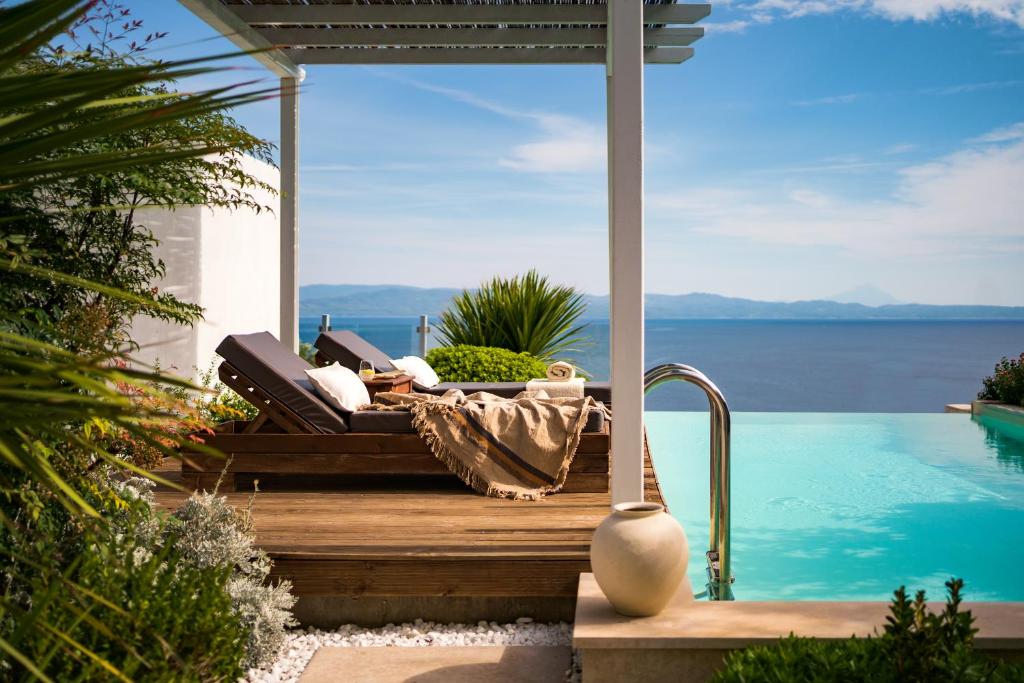 a bed on a deck next to a swimming pool at Kappa Resort in Paliouri