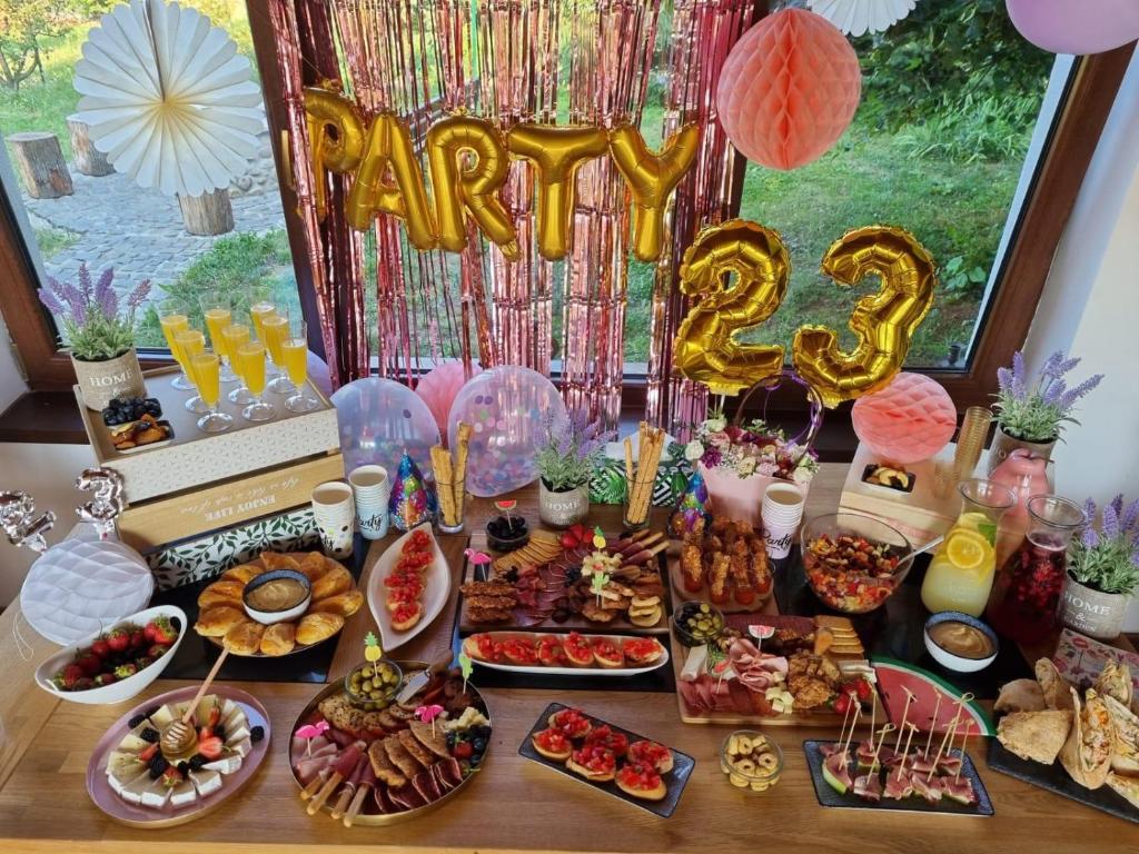 a table with food and a happy birthday at Casa Vatra Sinteului - Cu sala de evenimente de capacitate mare - Se inchiriaza integral in Socet