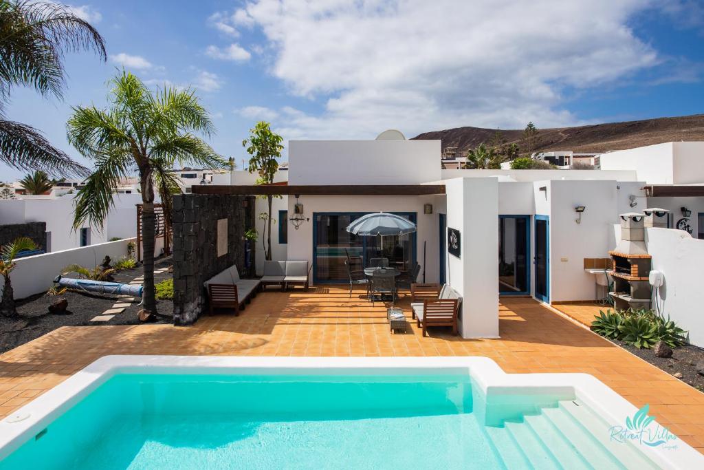 a villa with a swimming pool in front of a house at Captivating 2-Bed Villa in Playa Blanca in Playa Blanca