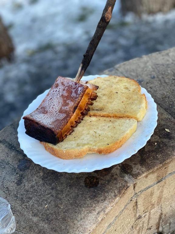 a piece of cake on a paper plate with a knife at Casa Vatra Sinteului - Cu sala de evenimente de capacitate mare - Se inchiriaza integral in Socet