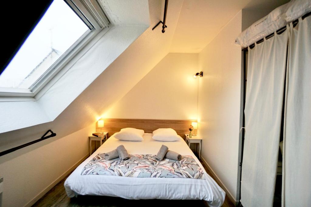 a bedroom with a large bed in a attic at Le duplex du quai mer in Concarneau