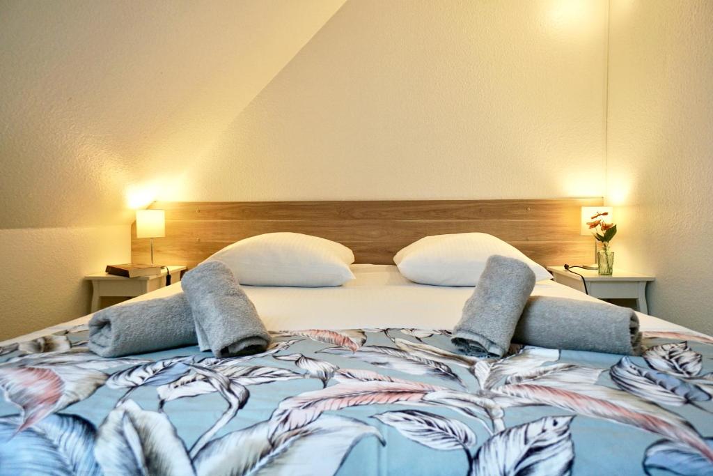 a bedroom with a large bed with two pillows at Le duplex du quai mer in Concarneau