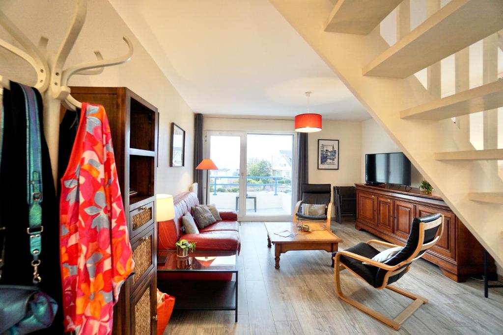 a living room with a couch and a tv at Le duplex du quai mer in Concarneau