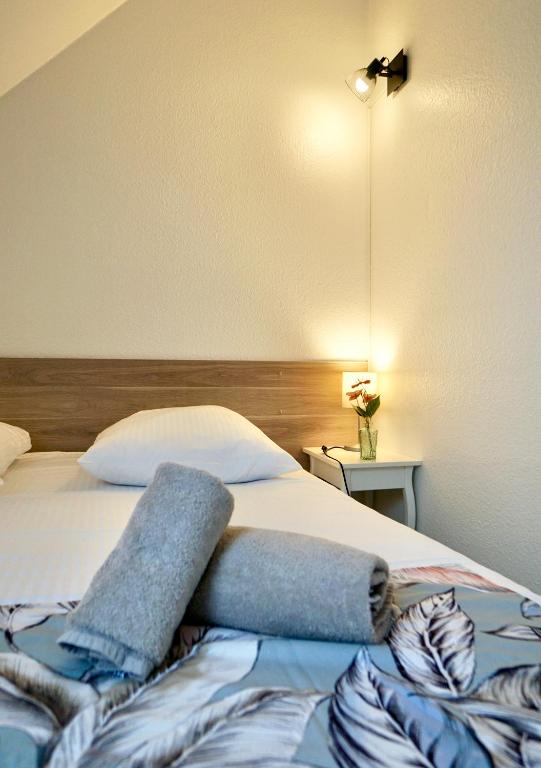 a bedroom with a bed with two towels on it at Le duplex du quai mer in Concarneau