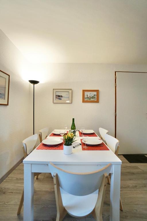 a white table with chairs and a bottle of wine at Le duplex du quai mer in Concarneau