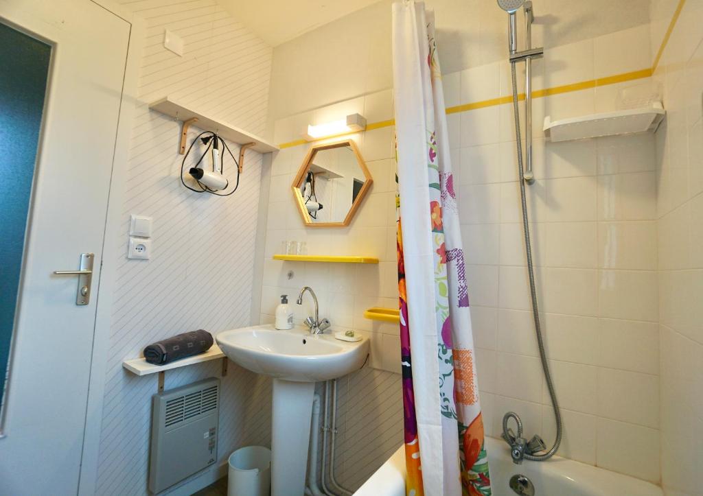 a small bathroom with a sink and a shower at Le duplex du quai mer in Concarneau