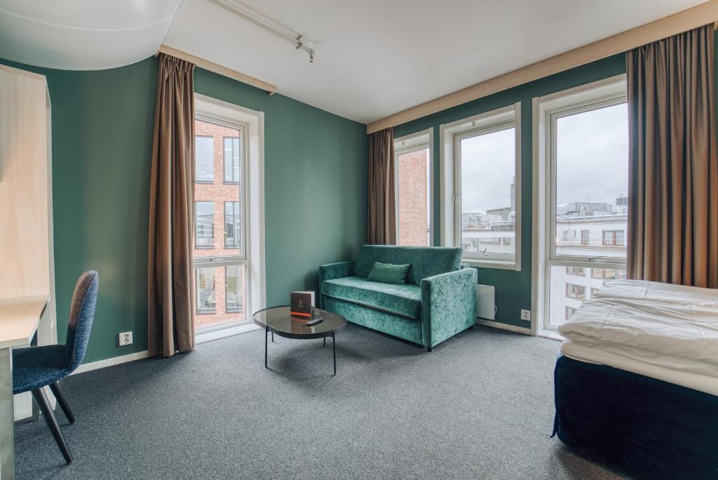 um quarto com uma cama, um sofá e uma mesa em Smarthotel Oslo em Oslo