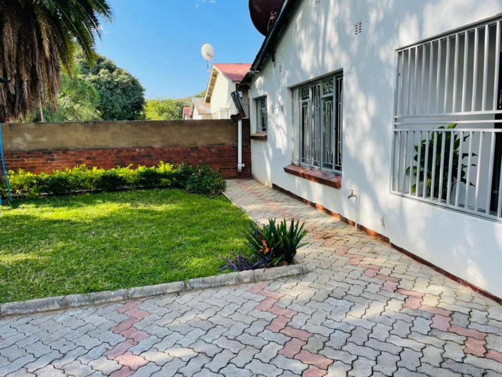 a house with a brick yard next to a building at Remarkable 2-Bed House in Bulawayo in Bulawayo