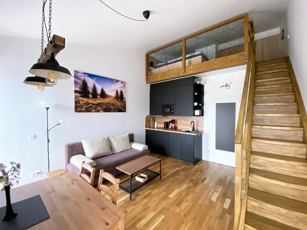 a loft apartment with a staircase and a living room at Miky Apartmán Klínovec view in Loučná pod Klínovcem