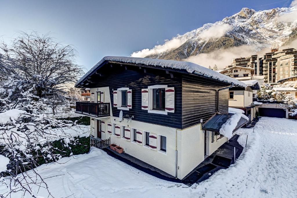 a small house in the snow with a mountain at Chalet Chintalaya in Chamonix-Mont-Blanc