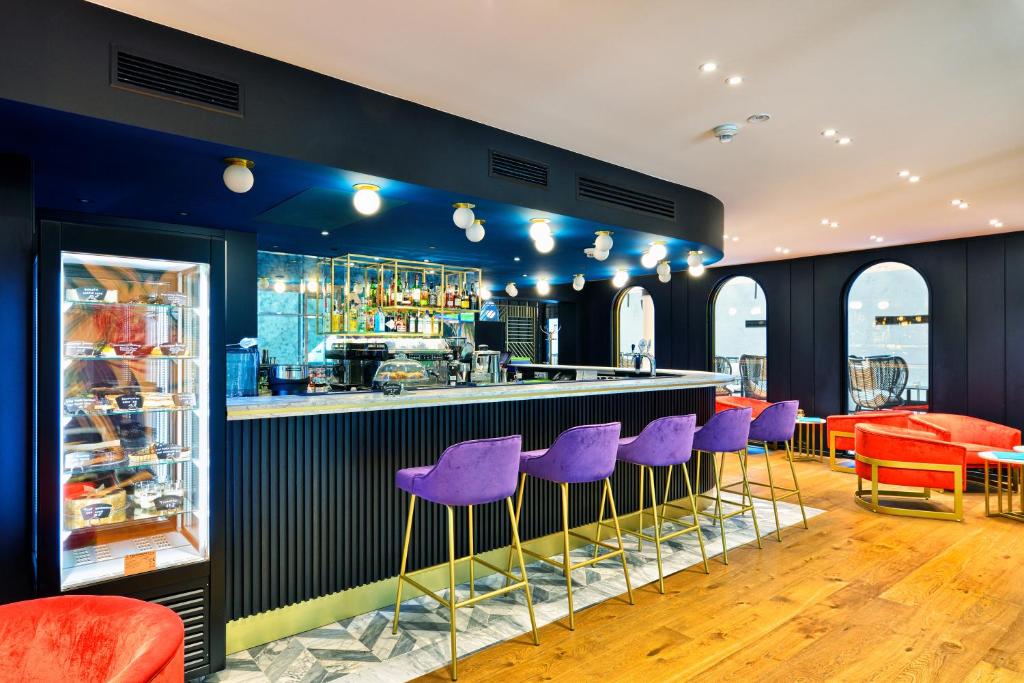 a bar with purple stools in a restaurant at Hotel Ferreus Modern Art Deco in Krakow