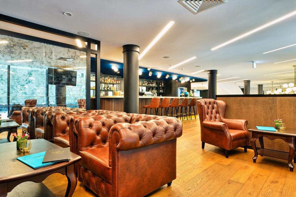 a bar with leather couches and a table and chairs at Hotel Ferreus Modern Art Deco in Krakow