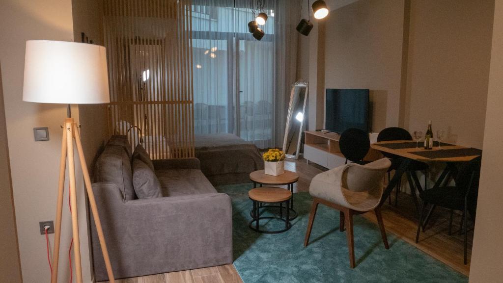 ein Wohnzimmer mit einem Sofa und einem Tisch in der Unterkunft Луксозно студио One Place in Sofia A1 - Лозенец in Sofia