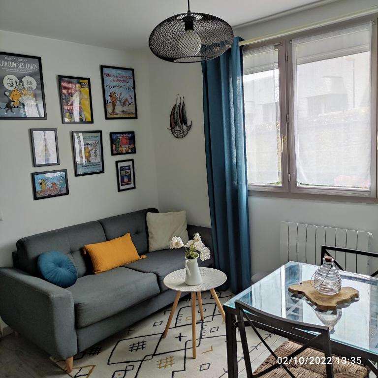 un salon avec un canapé et une table en verre dans l'établissement La Fleur d Honfleur avec son parking, à Honfleur