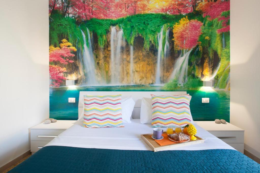 ein Schlafzimmer mit einem Bett und einem Wasserfall-Wandbild in der Unterkunft Room in BB - BB Sorrento Love You room Capri in Sorrent
