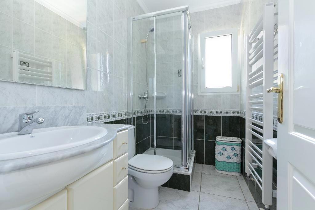 y baño blanco con aseo y ducha. en Casa Kaba en Dénia