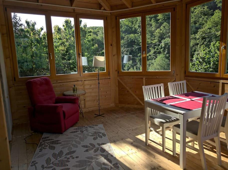 Cette chambre comprend une table, des chaises et des fenêtres. dans l'établissement Idyllische Ferienwohnung in Zentrumsnähe, à Dresde