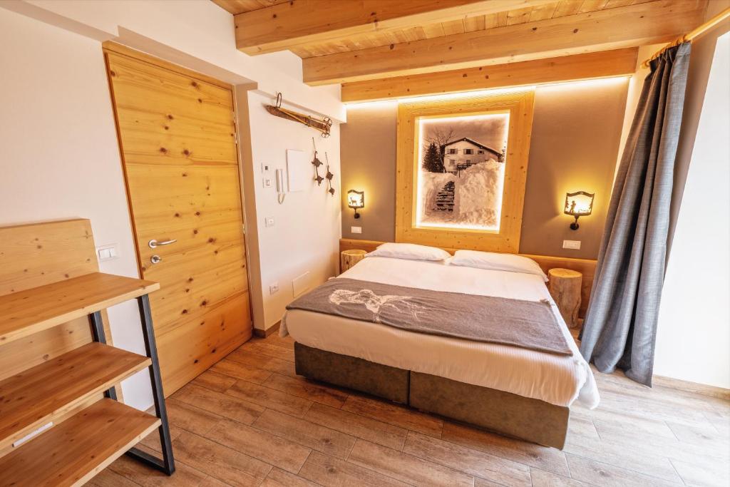 um quarto com uma cama num quarto em Wanderlust B&B em Folgaria