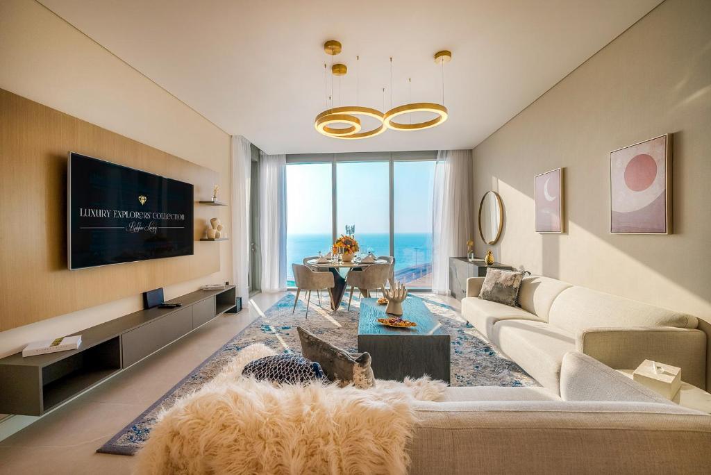 a living room with a couch and a tv and a table at Aria Apartment Dubai Marina -Two Bedroom Apartment By Luxury Explorer's Collection in Dubai Marina