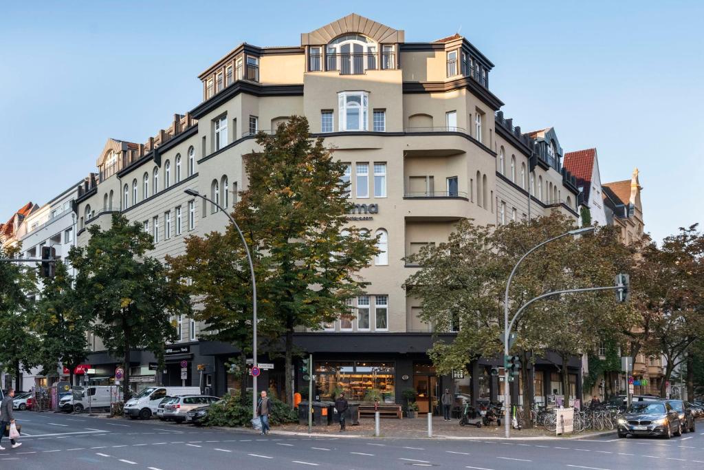a large building on a city street with cars parked in front at numa I Novela Rooms & Apartments in Berlin