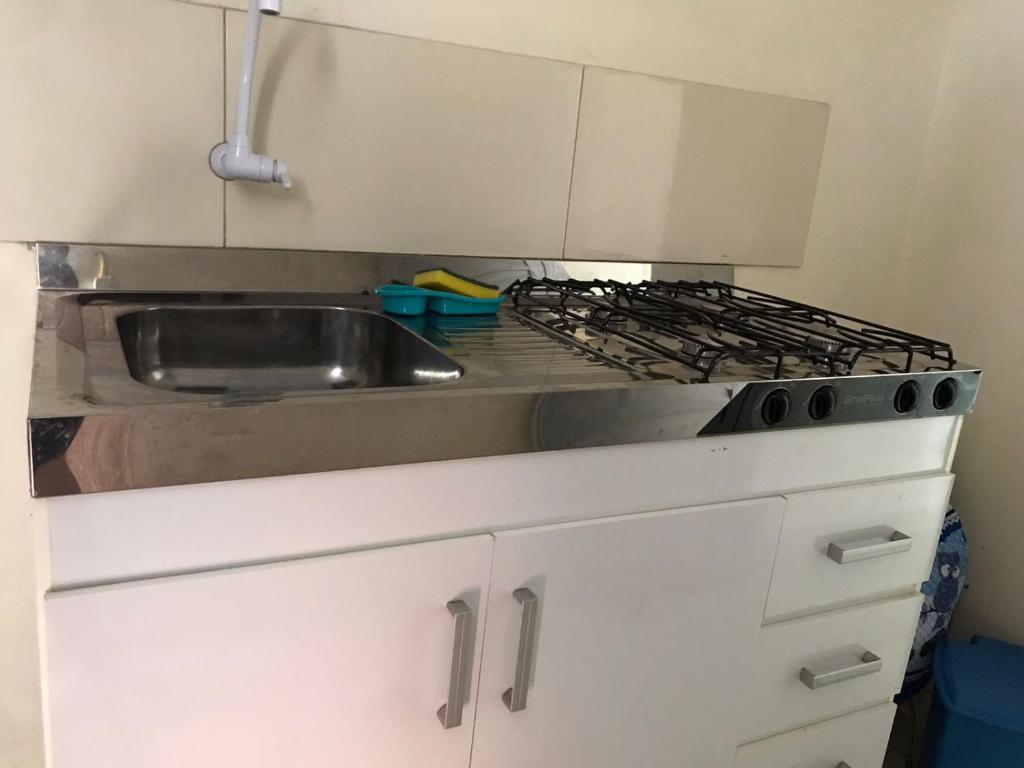 a kitchen with a sink and a stove at Recanto Magalhães in Barra do Garças