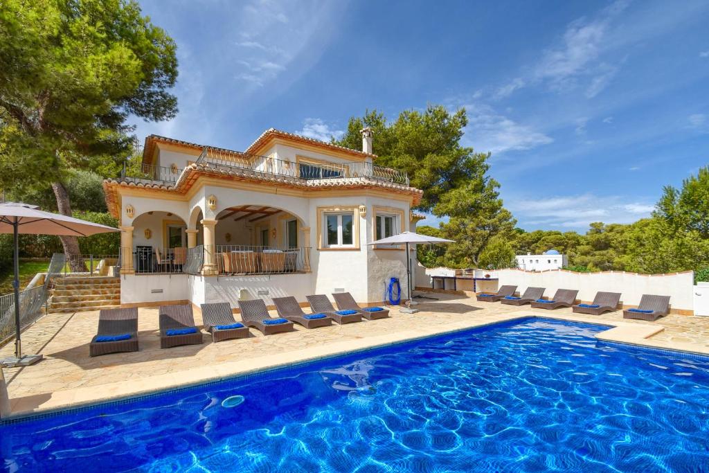 a villa with a swimming pool in front of a house at Anngo Dos in Jávea