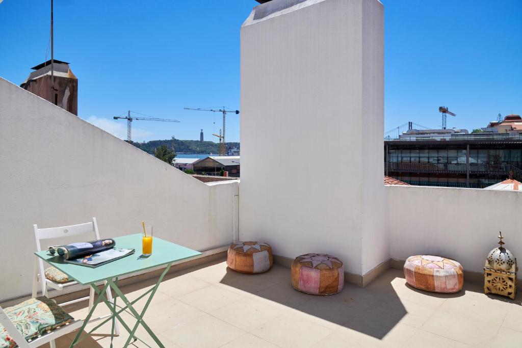 einen kleinen Balkon mit einem Tisch an einer weißen Wand in der Unterkunft Sunny Apartment with Terrace.River view! in Lissabon
