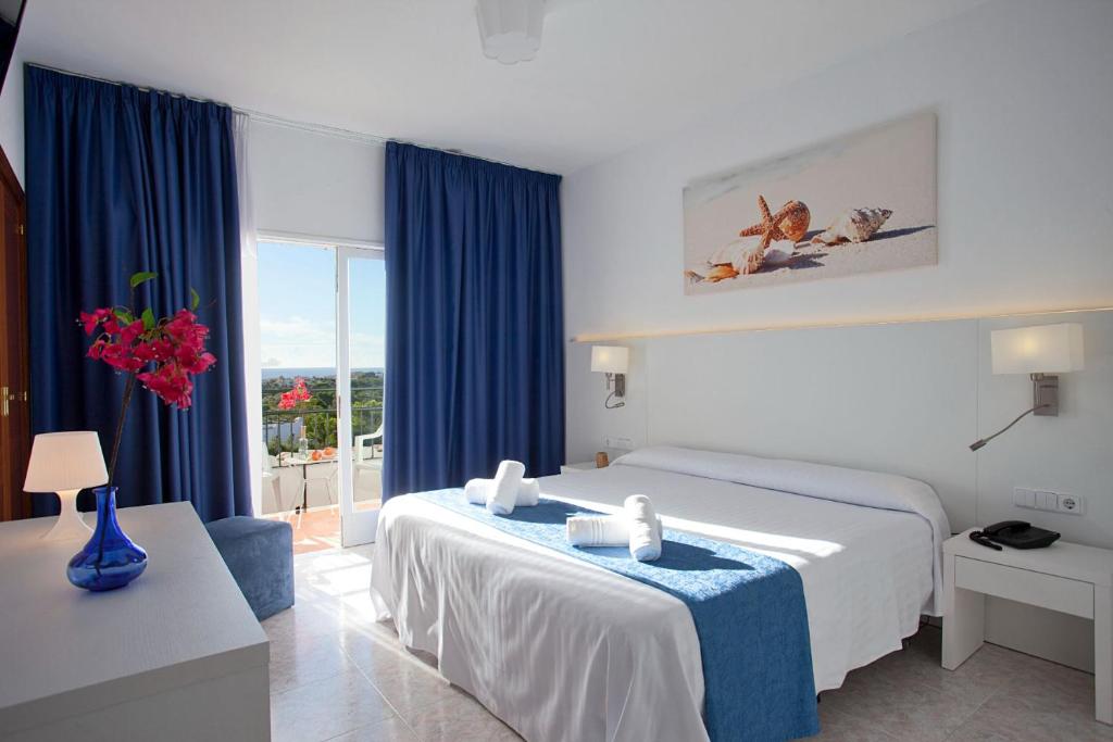 a hotel room with a bed and a window at Hotel Cala Murada in Cala Murada