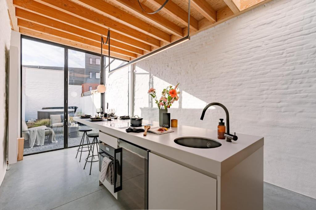 a kitchen with a sink and a large window at House K in Kortrijk