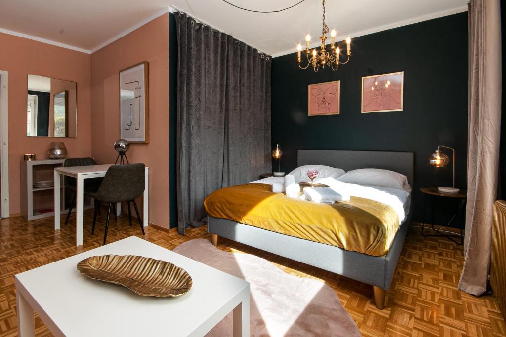 a bedroom with a bed and a living room at Schickes Boutique-Apartment, zentral in Messe-& Bahnhofsnähe, sehr ruhig & gratis Parkplatz - HappyStay in Klagenfurt