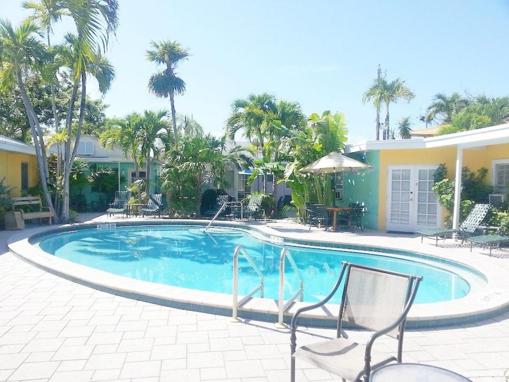 a swimming pool with two chairs and a house at Alexander Palms Court - No Hidden Resort Fees! in Key West