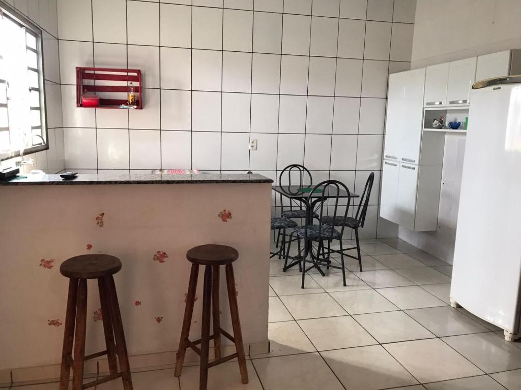 a kitchen with a counter and stools in a room at Espaço Magalhães in Barra do Garças