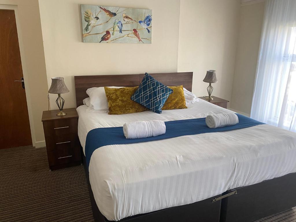a bedroom with a large bed with pillows on it at The New Brighton Hotel in New Brighton