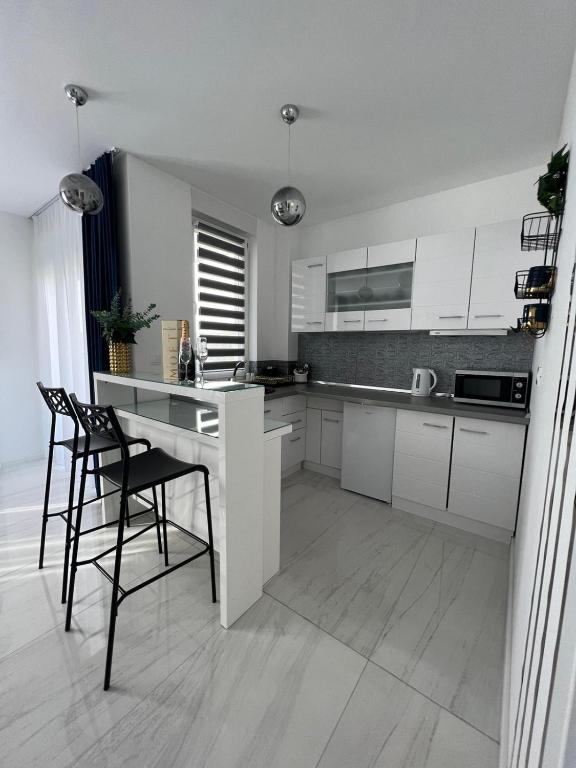 a kitchen with white cabinets and a table and chairs at MY PLACE in Slavonski Brod