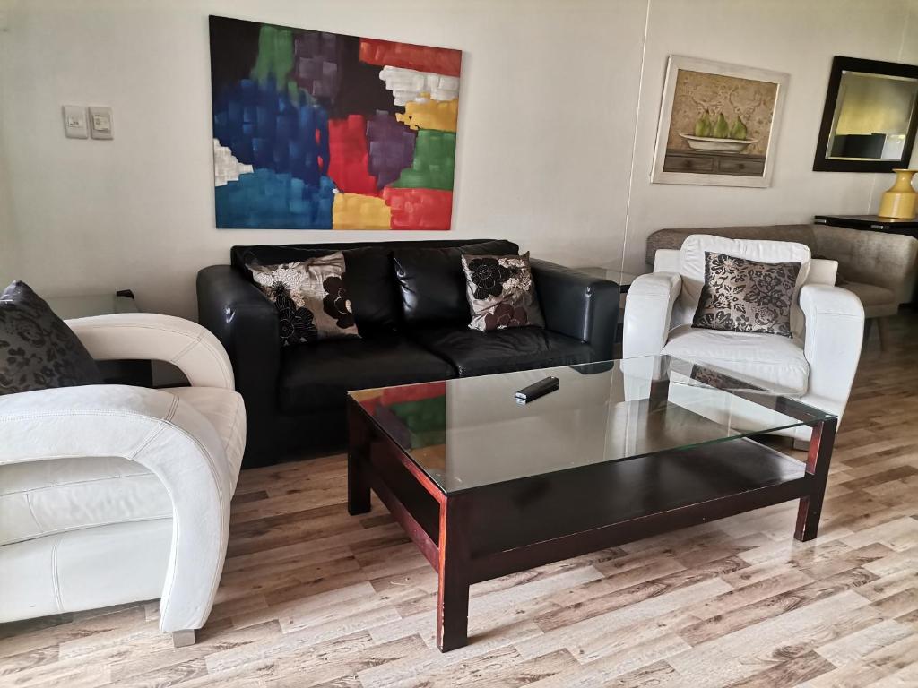a living room with a couch and a coffee table at Glammys @77 Grayston Drive in Johannesburg