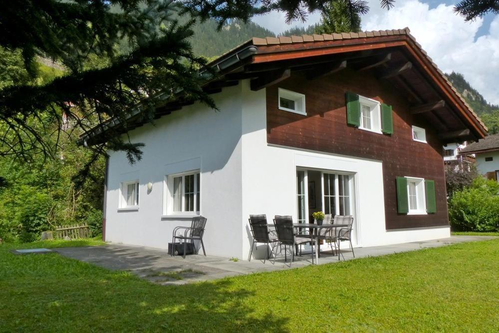 a house with chairs and a table in front of it at Haus Wick in Klosters Serneus