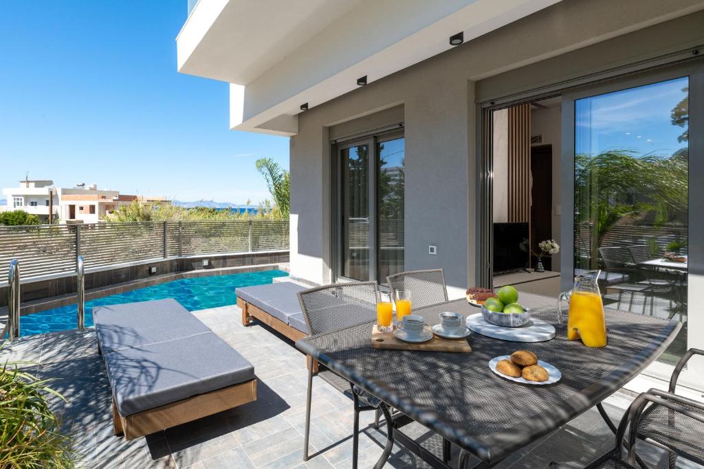 a patio with a table and chairs and a pool at ANIMA DEL SOL (BASILICO) in Ixia