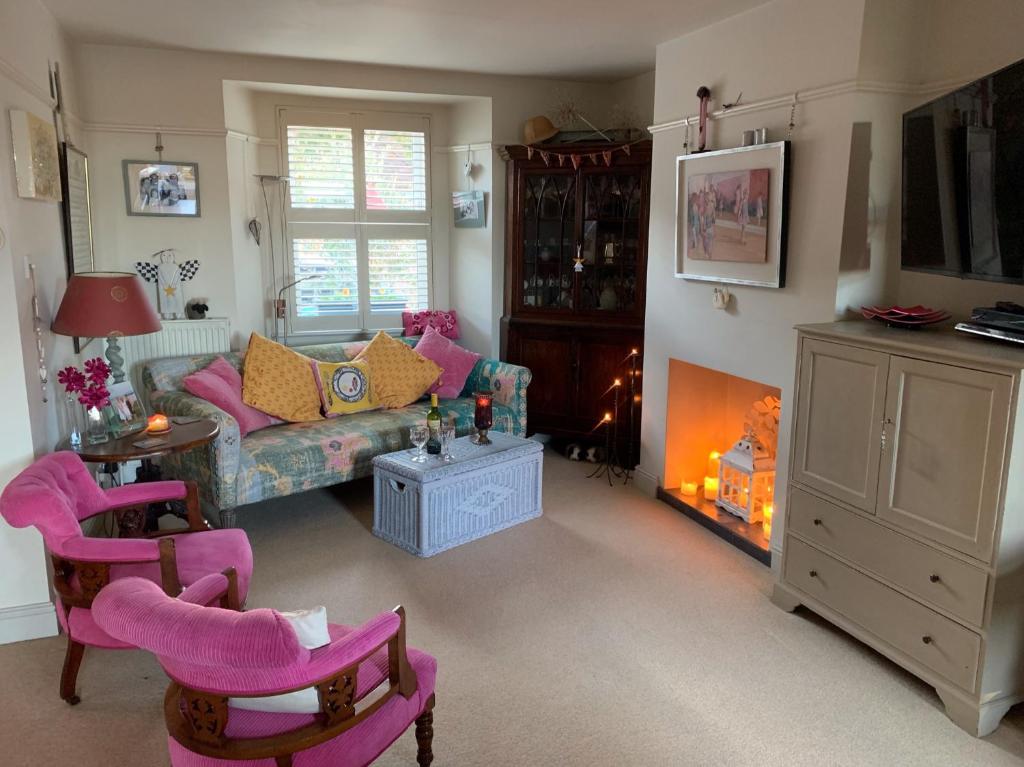ein Wohnzimmer mit rosa Stühlen und einem Sofa in der Unterkunft Magical, Stylish, Comfortable, Brilliant Location in Kent
