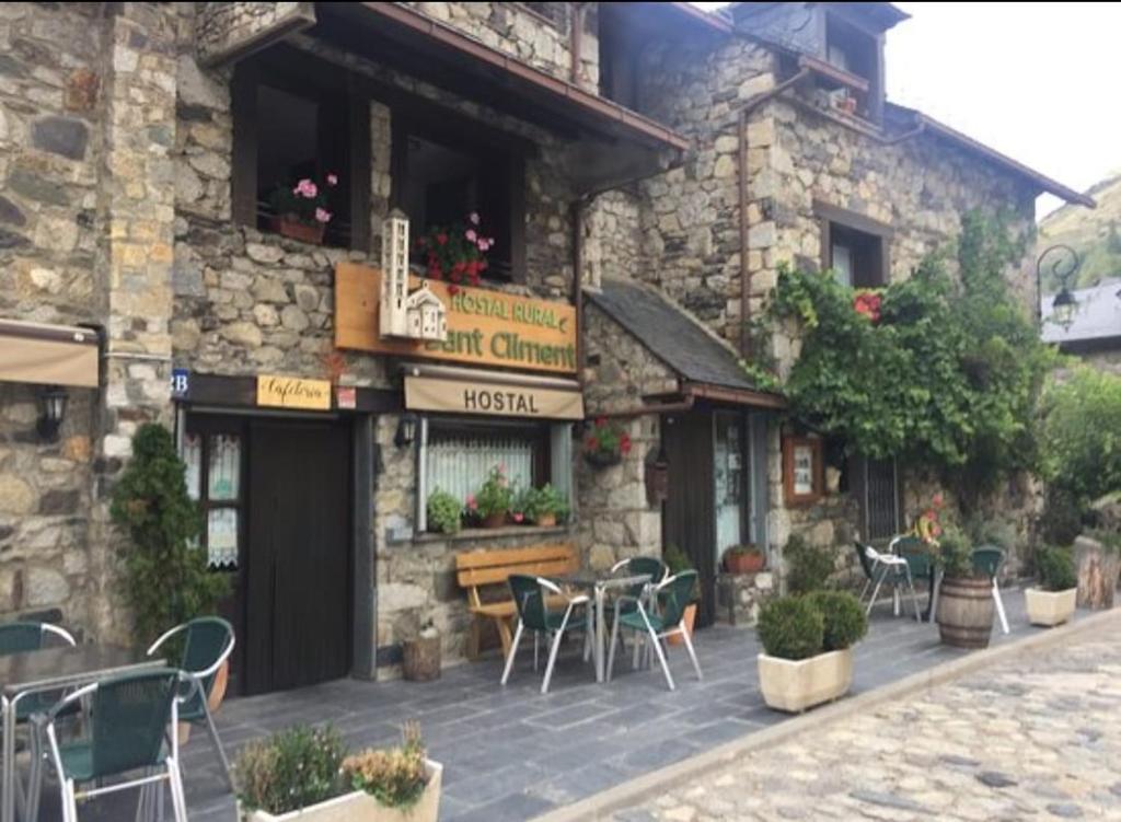 a restaurant with tables and chairs outside of a building at Hostal Rural Sant Climent in Taüll