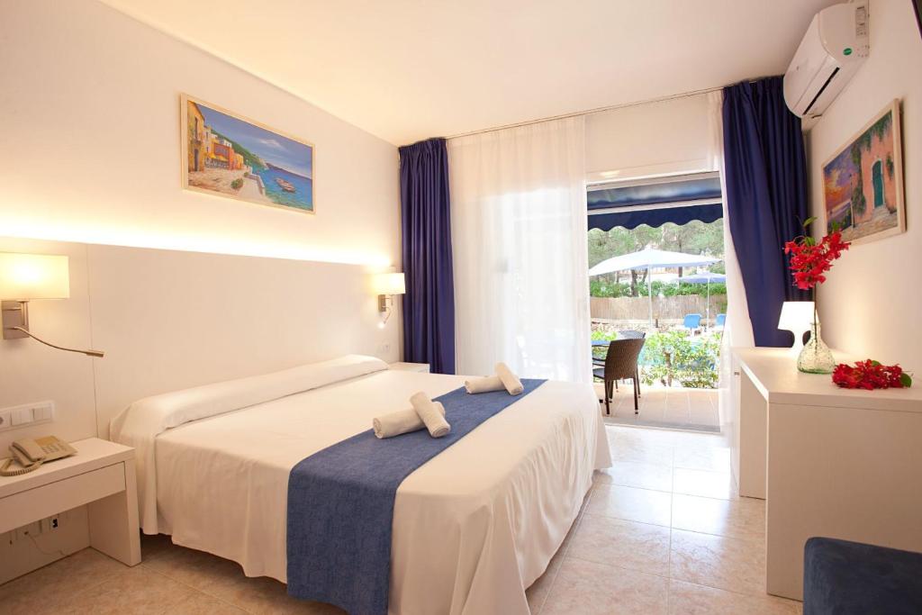 Una habitación de hotel con una cama y una ventana. en Apartamentos Cala Murada Minigolf, en Cala Murada