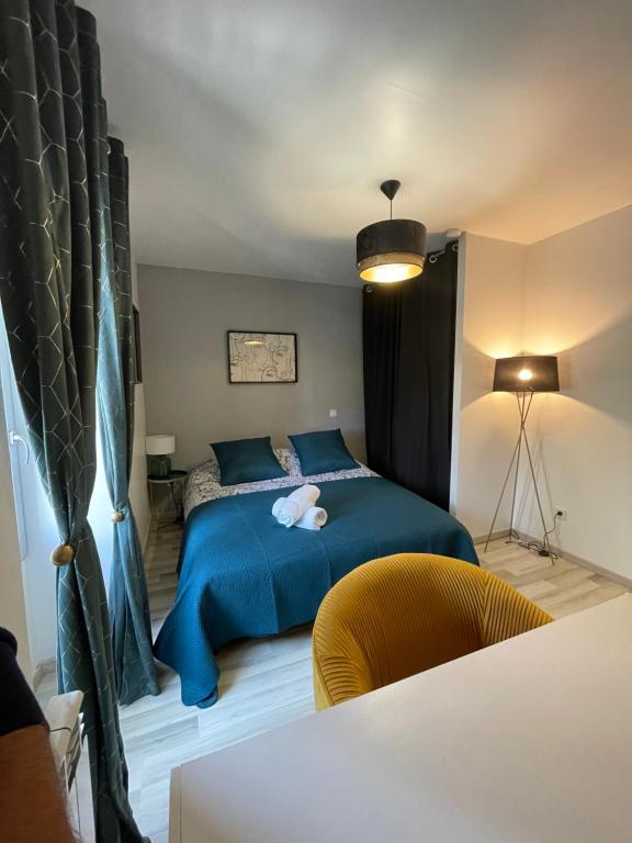 a bedroom with a blue bed and a yellow chair at Résidence Tamaris Soline in Lanvallay