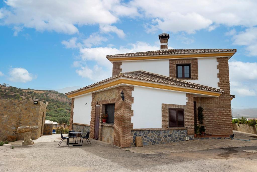 a small brick house with a table in front of it at Apartamento LLanos de belen in Ardales