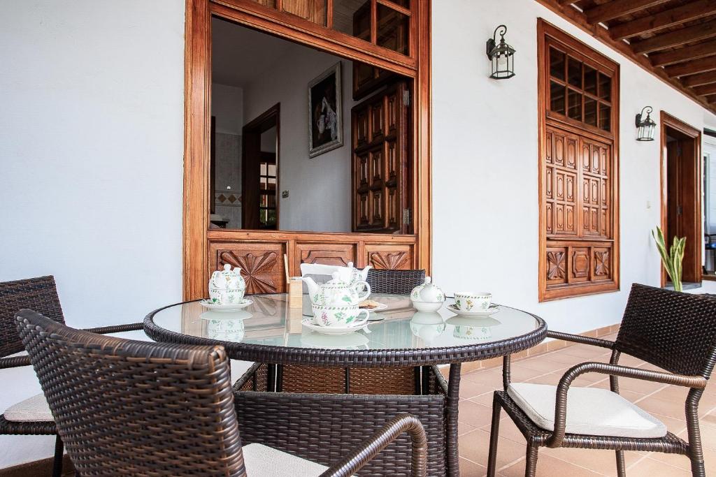 une salle à manger avec une table et des chaises en verre dans l'établissement Guanapay Home en el Centro de Teguise, à Teguise