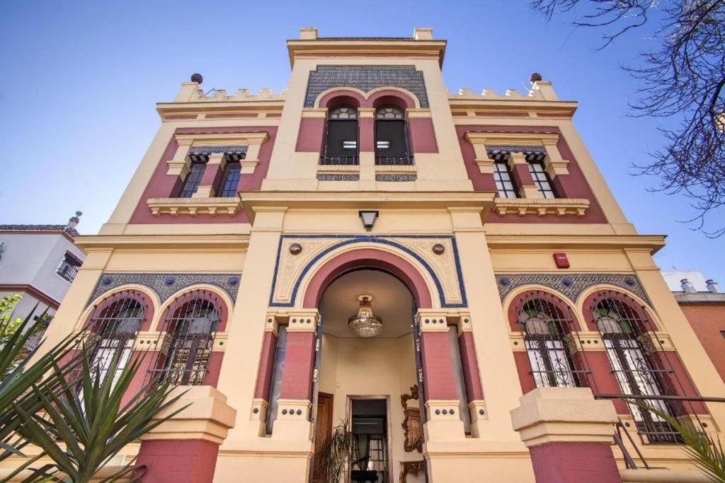 un grand bâtiment avec une tour d'horloge en haut dans l'établissement Palacete del Porvenir, à Séville