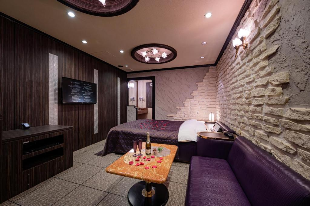 a hotel room with a bed and a couch at Hotel Metro (Adult Only) in Yokohama