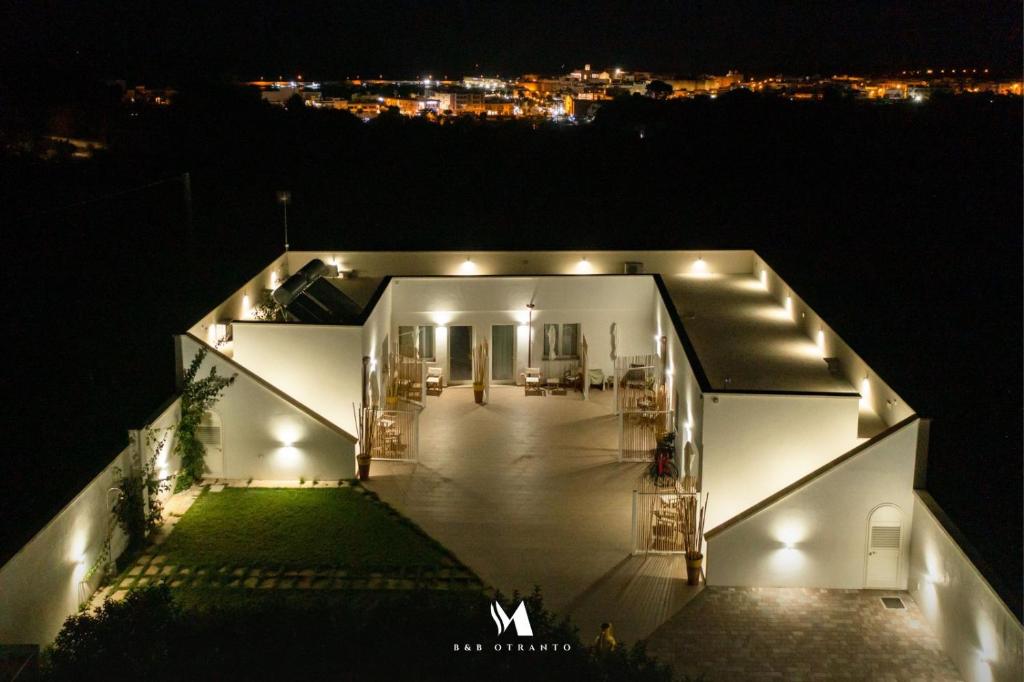 een uitzicht op een huis 's nachts met verlichting bij Murieri Rooms in Otranto
